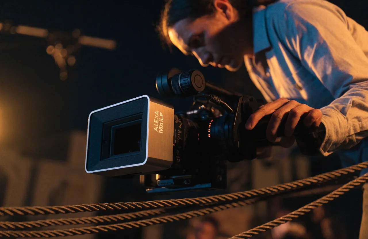 Cámara de cine full frame compacta sobre una caja gris de transporte en un cuarto oscuro