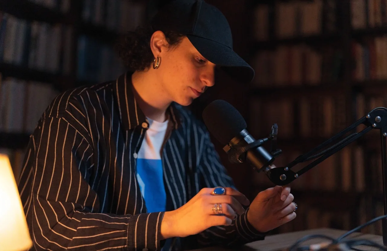 Creador grabando de noche con un micrófono USB en el escritorio