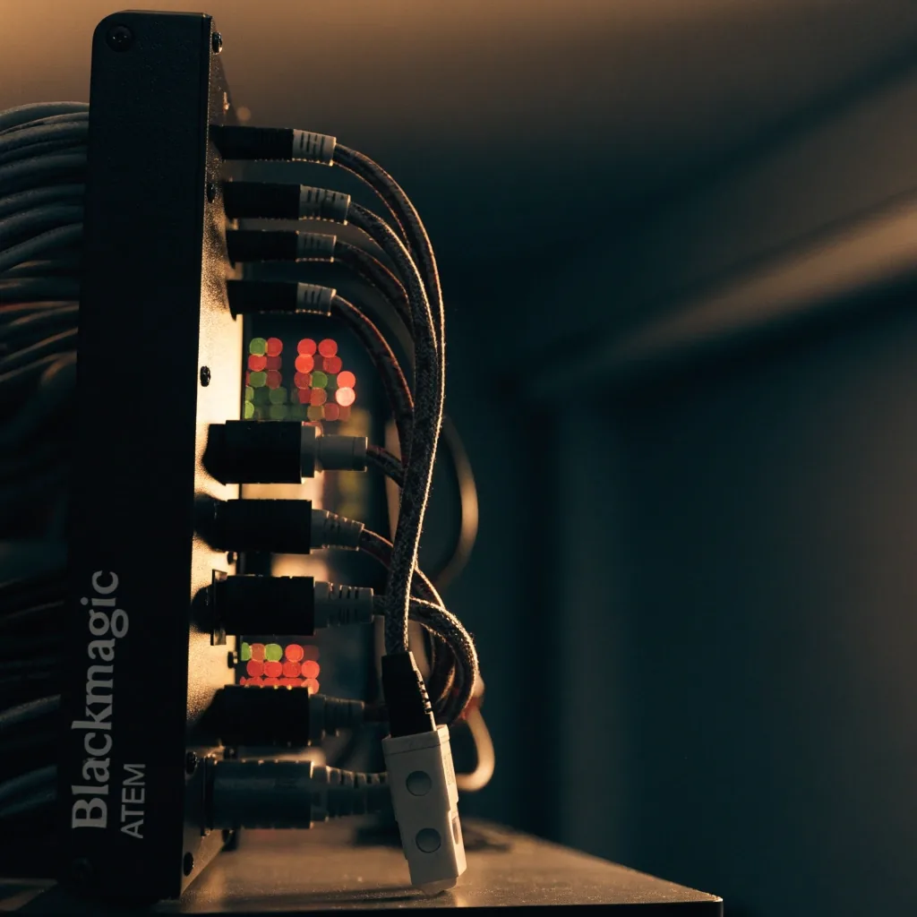 Switcher de video de costado sobre un counter oscuro con cables trenzados